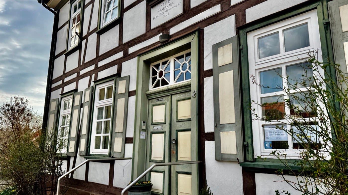 Historisches Fachwerk-Stiftspfarrhaus in Hildesheim mit grüner Haustür und der Inschrift „Stifts Pfarrhaus 1823“
