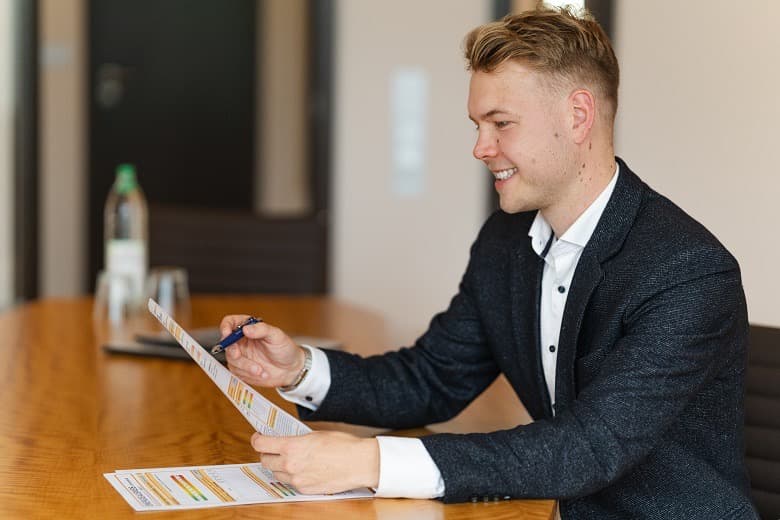 Moritz Becker begleitet eine Vertragsunterschrift in einer persönlichen Beratungssituation